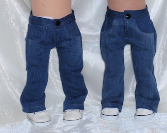 May include: Two pairs of doll-sized blue denim jeans with a button closure and front pockets. The jeans are paired with white canvas sneakers with black trim.