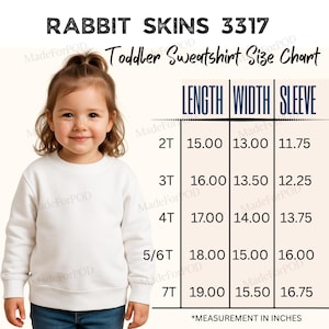 Puede incluir: Un niño con una sudadera blanca para niños pequeños. La imagen incluye una tabla de tallas con medidas en pulgadas para largo, ancho y manga para tallas de 2T a 7T. La marca "RABBIT SKINS 3317" es visible.