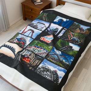 May include: Black blanket featuring a collage of roller coaster images. The blanket has a black border and the words "Airline Soul" in white. The images show various roller coasters with blue skies and green trees.