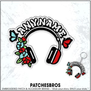 May include: Embroidered patch and keychain featuring a headphone design with the text "ANYNAME". The headphones are black with red accents, adorned with flowers and butterflies. The keychain mirrors the patch design.