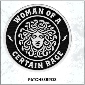 May include: Embroidered patch featuring a black and white Medusa design with the text "WOMAN OF A CERTAIN RAGE". The patch has a circular shape with a white border and lightning bolt accents. The text "PATCHESBROS" is at the bottom.