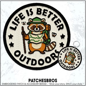 May include: Embroidered patch and keychain set with a raccoon design. The patch features a raccoon with a backpack, map, and walking stick, with the text "LIFE IS BETTER OUTDOORS". The keychain has the same design. The brand name "PATCHESBROS" is at the bottom.
