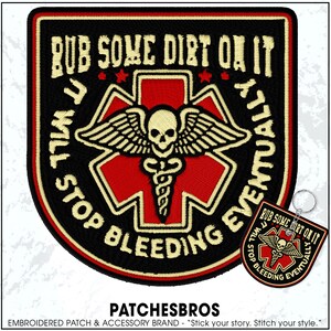 May include: Black embroidered patch with the text "RUB SOME DIRT ON IT, YOU WILL STOP BLEEDING EVENTUALLY." The patch features a red cross with a skull and wings design. A smaller keychain version is also visible.