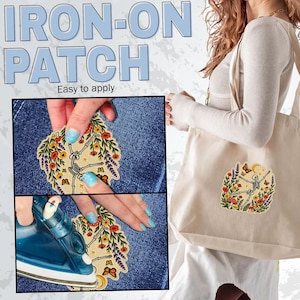 May include: An iron-on patch featuring a skeleton dancing amidst colourful flowers, butterflies, and mushrooms. The patch is shown being applied to blue denim fabric with an iron and is also displayed attached to a beige canvas tote bag.