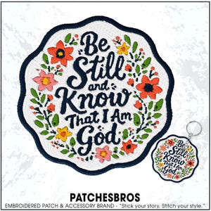 May include: Embroidered patch with the text "Be Still and Know That I Am God" surrounded by floral designs in orange, pink, and yellow. A matching keychain is also shown. The patch has a navy blue border.