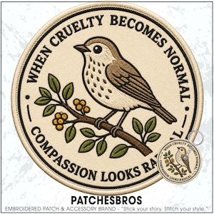 May include: A circular embroidered patch and a matching keychain featuring a brown bird perched on a branch with green leaves and yellow berries. The text "WHEN CRUELTY BECOMES NORMAL, COMPASSION LOOKS RADICAL" is stitched in black around the border.