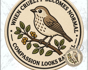 May include: A circular embroidered patch and a matching keychain featuring a brown bird perched on a branch with green leaves and yellow berries. The text "WHEN CRUELTY BECOMES NORMAL, COMPASSION LOOKS RADICAL" is stitched in black around the border.