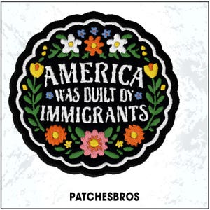 May include: Embroidered patch with the text "AMERICA WAS BUILT BY IMMIGRANTS" in white, surrounded by colorful flowers on a black background. The patch has a scalloped edge and the brand name "PATCHESBROS" is at the bottom.
