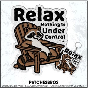 May include: Embroidered patch featuring a raccoon relaxing in a wooden chair. The patch has the words "Relax, Nothing Is Under Control" in black text. A smaller keychain with the same design is also visible.