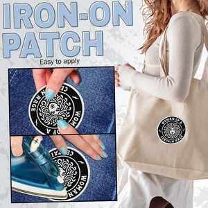 May include: An iron-on patch with the text "WOMAN OF A CERTAIN RAGE" in a circular design. The image shows the patch being applied to denim fabric with an iron. A tote bag with the same patch is also visible.