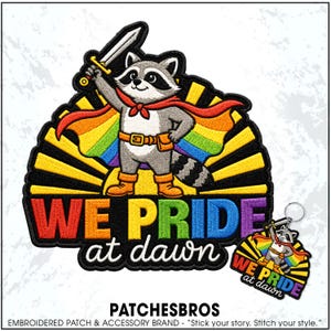 May include: An embroidered patch and matching keychain featuring a cartoon raccoon wearing a red cape and orange boots, holding a sword. The raccoon stands before a yellow sunburst and rainbow background with the text WE PRIDE at dawn in bold colors.