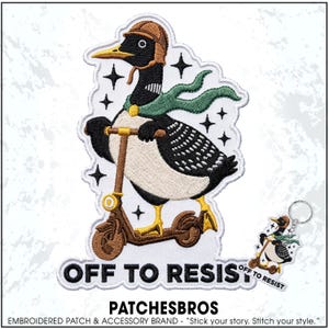 May include: An embroidered patch and matching keychain featuring a black and white goose wearing a brown aviator helmet and a green scarf, riding a brown scooter. The design includes black star accents and the text OFF TO RESIST in bold black letters.