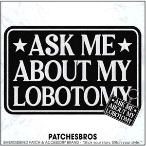 May include: A rectangular black embroidered patch with a white border and white text that reads ASK ME ABOUT MY LOBOTOMY, flanked by two white stars. A smaller version of the same design is attached to a silver metal keychain ring in the corner.