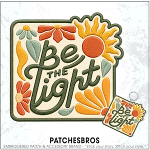May include: A square embroidered patch and a matching keychain featuring the text "be the light" in dark green cursive script. The design includes a bright orange sun, stylized orange and light blue flowers, and green leaves on a cream background.