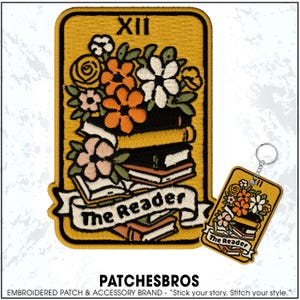 May include: Embroidered patch and keychain set featuring a floral design with books and the text "The Reader." The patch is rectangular with a yellow background and a black border. The keychain has a similar design.