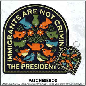 May include: Embroidered patch and keychain set with a navy blue background. The patch features colorful birds, flowers, and the text "IMMIGRANTS ARE NOT CRIMINALS THE PRESIDENT IS." The keychain mirrors the patch design.