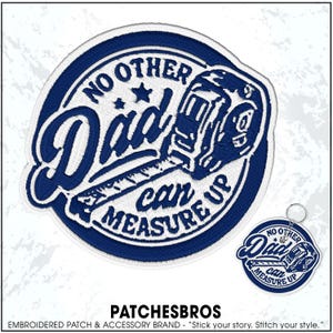 May include: A circular embroidered patch and a matching circular keychain featuring a dark blue and white design. The text reads NO OTHER Dad can MEASURE UP, accompanied by an embroidered graphic of a tape measure and two small stars.