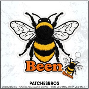 May include: An embroidered patch featuring a large bumblebee with black and yellow stripes and white wings, positioned above the orange text Been. A smaller matching bumblebee keychain with the text Been is attached to the lower right side.