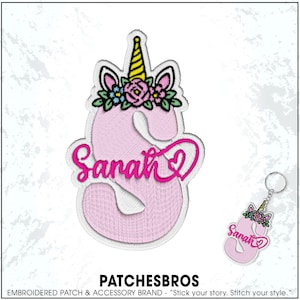 May include: A pink embroidered patch in the shape of the number 3, with a unicorn horn and floral crown. The name "Sarah" is written in pink script. A matching keychain is also shown. The brand name "PATCHESBROS" is at the bottom.