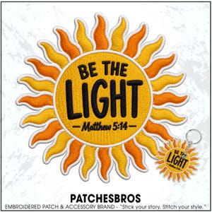 May include: A circular embroidered patch and a matching keychain featuring a yellow sun with orange rays. The center text reads BE THE LIGHT and Matthew 5:14 in black embroidery. The design is set against a white background with the text PATCHESBROS.