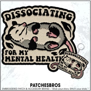 May include: Embroidered patch featuring a cartoon opossum lying on its back, with the words "DISSOCIATING FOR MY MENTAL HEALTH." A matching keychain is also shown. The patch has a cream background with black, gray, and pink details.