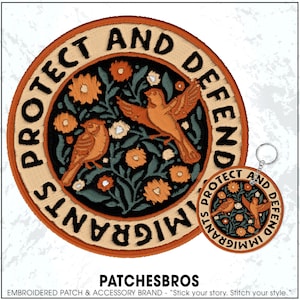 May include: Embroidered patch and keychain featuring a circular design with the words "PROTECT AND DEFEND IMMIGRANTS." The design includes orange birds, flowers, and green leaves on a black background, with a tan border.