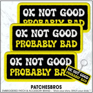 May include: Embroidered patches and a keychain with the phrase "OK NOT GOOD PROBABLY BAD" in white and yellow lettering on a black background. The patches have a yellow border. The brand name "PATCHESBROS" is at the bottom.