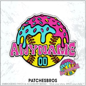 May include: An embroidered patch and matching keychain featuring a yellow softball with red stitching, topped with pink icing and blue sprinkles. The text ANYNAME is embroidered in pink, with the number 00 in blue below the text on the softball.