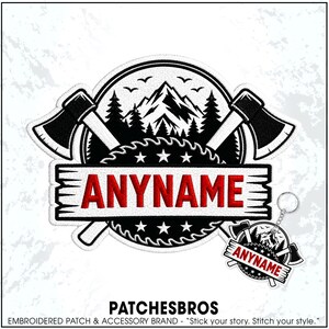 May include: An embroidered patch and matching keychain featuring a circular design with two crossed axes, a mountain range, pine trees, and a saw blade. A white rectangular banner across the center displays the red text ANYNAME in capital letters.