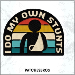 May include: Embroidered patch with the text "I DO MY OWN STUNTS" in a semi-circular design. The patch features a stick figure with an arm in a sling, set against a retro sunset of red, yellow, teal, and white stripes. The brand name "PATCHESBROS" is at the bottom.