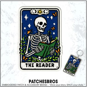 May include: Embroidered patch and keychain featuring a skeleton reading a book, set against a starry blue background. The patch and keychain have the text "THE READER" at the bottom. The patch is rectangular with a white border.