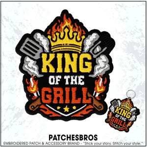 May include: An embroidered patch and matching keychain featuring a yellow crown atop the text KING OF THE GRILL in yellow and orange. The design includes grey spatula and tongs with white smoke, orange flames, and a black border on a shield shape.
