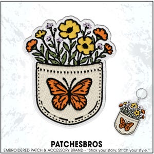 May include: Embroidered patch and keychain set featuring a pocket design with a butterfly and flowers. The patch has a cream-colored pocket with an orange butterfly and colorful flowers. The keychain mirrors the patch design.