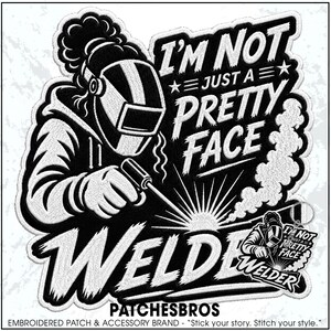 May include: A black and white embroidered patch featuring a welder wearing a protective helmet and holding a welding torch. The text reads I'M NOT JUST A PRETTY FACE WELDER. A smaller version of the same design is attached as a metal keychain.