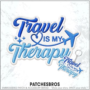 May include: An embroidered patch and a matching keychain featuring the blue text Travel is my Therapy with a heart and an airplane icon. The design includes four small star shapes and is rendered in shades of blue thread on a white background.