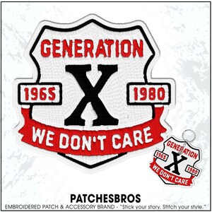May include: A shield-shaped embroidered patch featuring the text GENERATION X, the years 1965 and 1980, and the phrase WE DON'T CARE in red, black, and white thread. A smaller version of the same design is attached to a silver metal keychain ring.