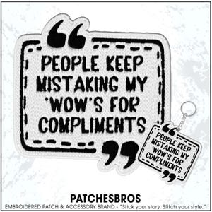 May include: Embroidered patch and keychain set with the quote "PEOPLE KEEP MISTAKING MY 'WOW'S FOR COMPLIMENTS." The patch is white with black stitching and text, shaped like a speech bubble. The keychain has a similar design.