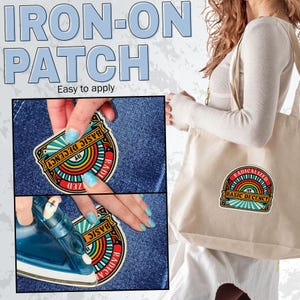 May include: An iron-on patch with the text "RADICALIZED BY BASIC DECENCY" in a colorful design. The image shows the patch being applied to denim with an iron. A tote bag with the same patch design is also visible.