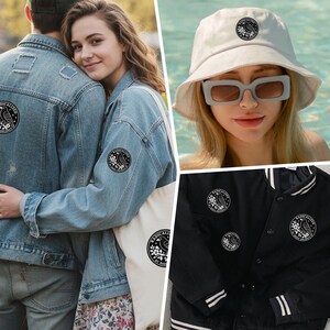 May include: A collection of apparel and accessories featuring a circular black and white patch with a bird on a branch and the text RADICALIZED BY BASIC DECENCY. Items include a denim jacket, a canvas tote bag, a white bucket hat, and a black jacket.