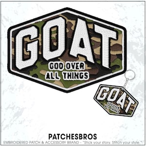 May include: Embroidered patch and keychain set. The patch and keychain feature the word "GOAT" in white, outlined in black, over a camouflage pattern. The text "GOD OVER ALL THINGS" is below. The brand name "PATCHESBROS" is at the bottom.