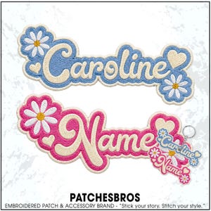May include: Two custom embroidered patches featuring the names Caroline and Name in cursive script. The Caroline patch has blue borders with white daisies and hearts, while the Name patch has pink borders with white daisies and hearts.