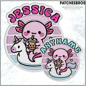 May include: Embroidered patches featuring a pink axolotl riding a unicorn and holding a boba drink. The patches have the names "JESSICA" and "ANYHAME" in bubble letters. The patches are circular with a striped background and a light blue border.