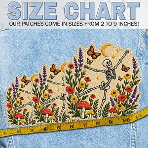 May include: An embroidered patch featuring a skeleton dancing among colourful wildflowers, mushrooms, butterflies, and a crescent moon. The patch is displayed on blue denim with a yellow measuring tape showing sizes from 5 to 23 cm.