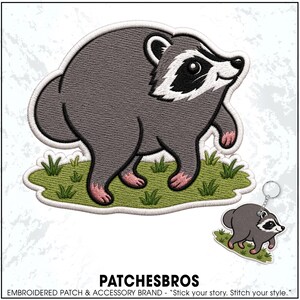 May include: An embroidered patch and a matching keychain featuring a cartoon raccoon with gray fur, a black eye mask, and pink paws, standing on a patch of green grass. The text PATCHESBROS EMBROIDERED PATCH & ACCESSORY BRAND - "Stick your story. Stitch your style." is below.