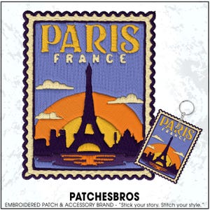May include: Embroidered patch and keychain featuring a design of the Eiffel Tower in Paris, France. The patch and keychain have a postage stamp design with the text "PARIS FRANCE" in yellow. The background features a sunset.