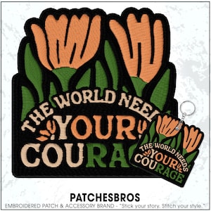 May include: Embroidered patch and keychain featuring a floral design with the text "THE WORLD NEEDS YOUR COURAGE." The patch and keychain have a black background with orange flowers and green leaves.