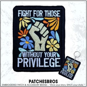 May include: Black embroidered patch with the text "FIGHT FOR THOSE WITHOUT YOUR PRIVILEGE" and a raised fist design. The patch is decorated with colorful flowers. A matching keychain is also shown.