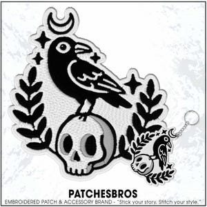May include: Embroidered patch featuring a black raven perched atop a skull, surrounded by a crescent moon, stars, and foliage. A smaller keychain version is attached. The text "PATCHESBROS" is at the bottom.
