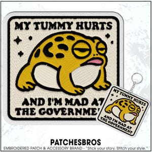 May include: Embroidered patch and keychain featuring a yellow frog with the text "MY TUMMY HURTS AND I'M MAD AT THE GOVERNMENT." The frog has a tired expression. The patch is square with a white border.