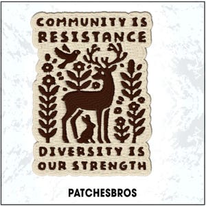 May include: Embroidered patch with the text "COMMUNITY IS RESISTANCE" and "DIVERSITY IS OUR STRENGTH". The patch features a brown deer, bird, and rabbit design with floral and leaf accents. The brand name "PATCHESBROS" is at the bottom.